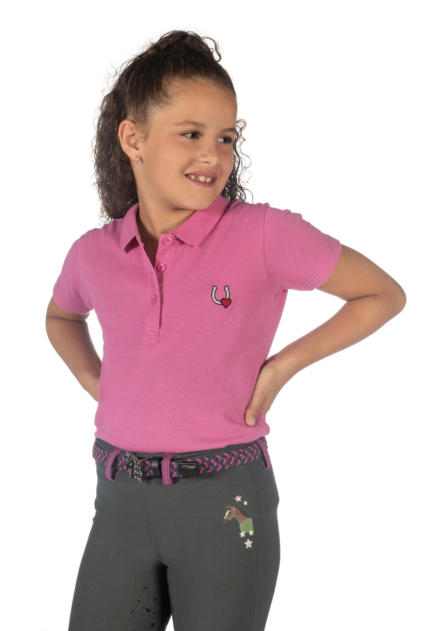 Young girl modeling a pink polo shirt with a horseshow and heart logo