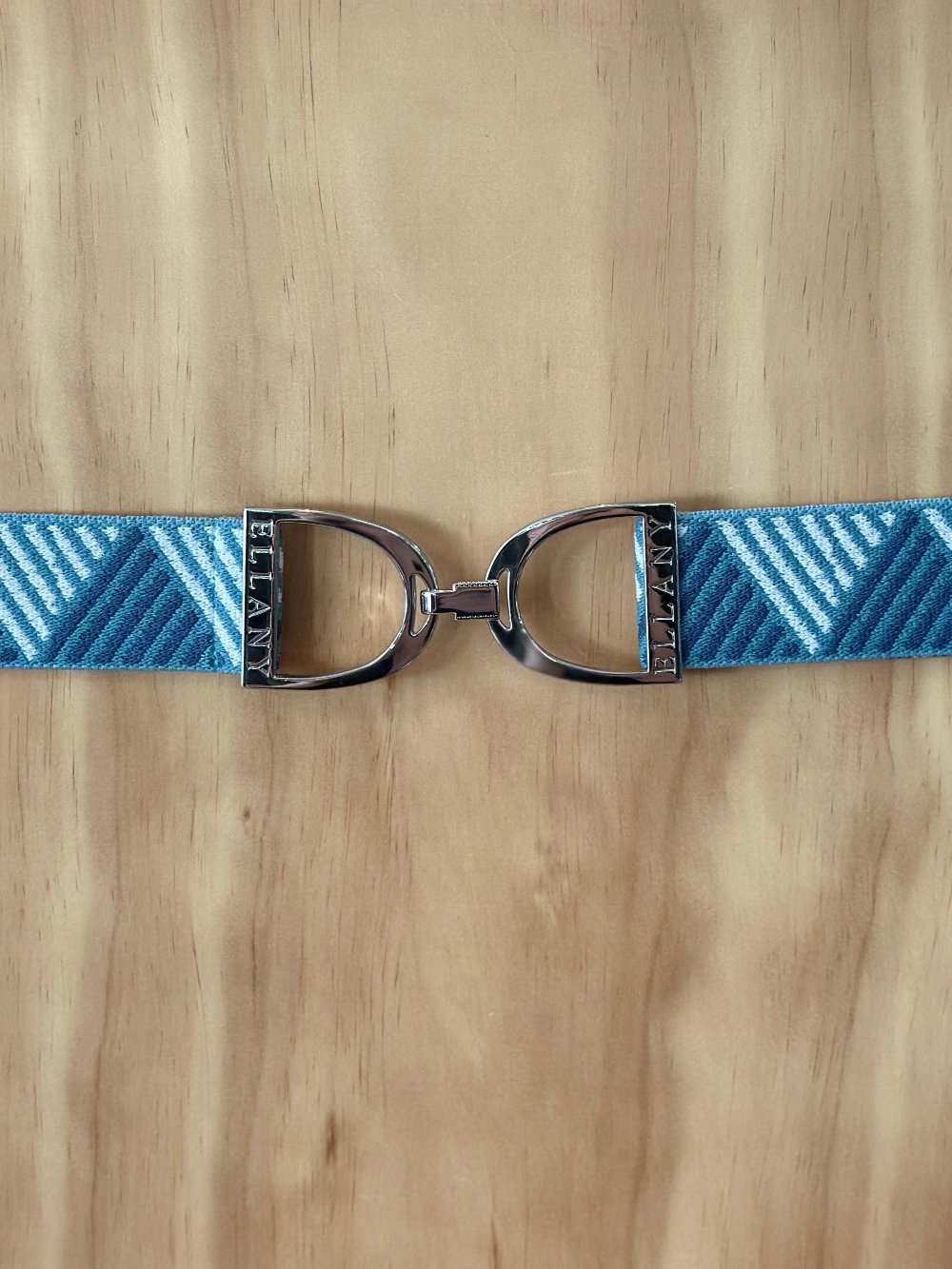 Shades of light blue textured elastic belt with a silver buckle that looks like a pair of equestrian stirrups