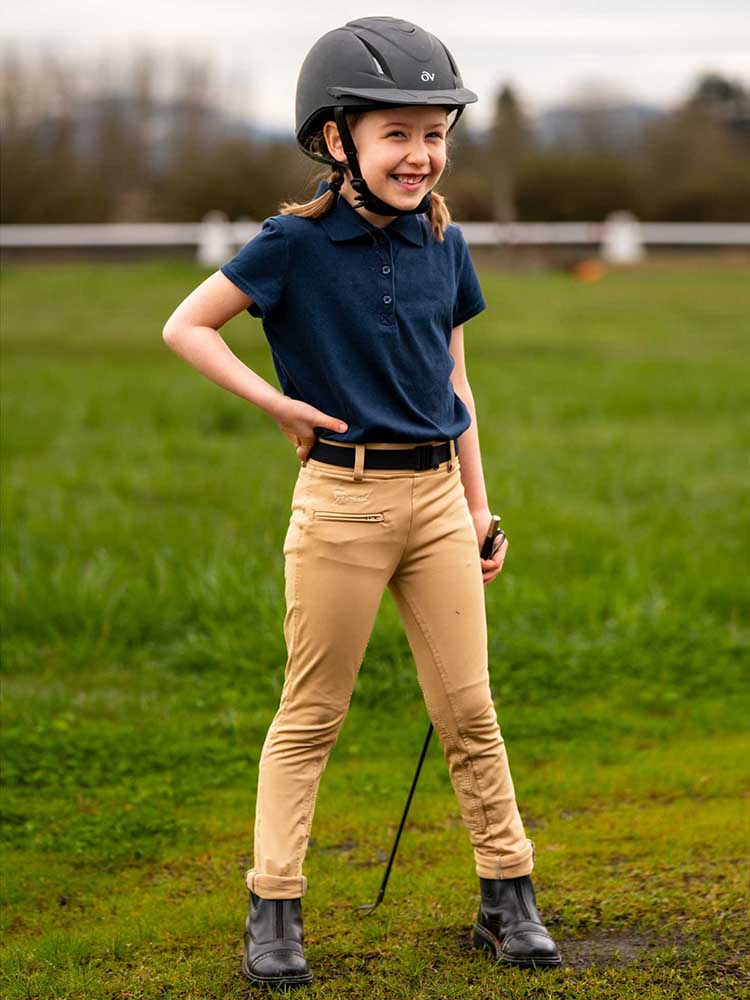 Young girl dressed to ride her horse.