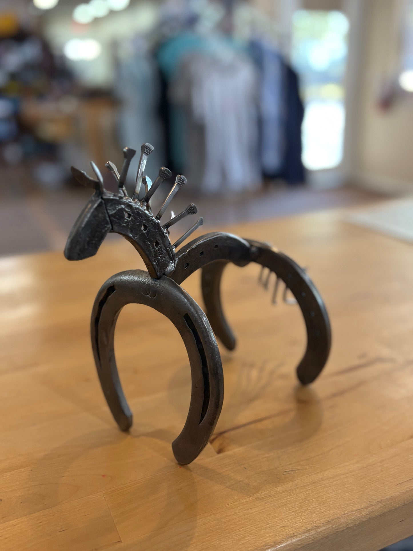 Decorative horseshoe with a horse head design on a wooden surface