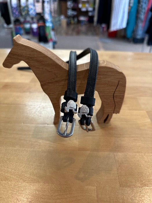 black leather spur straps with silver buckles, with silver margarita drink charm. sitting on wood horse model
