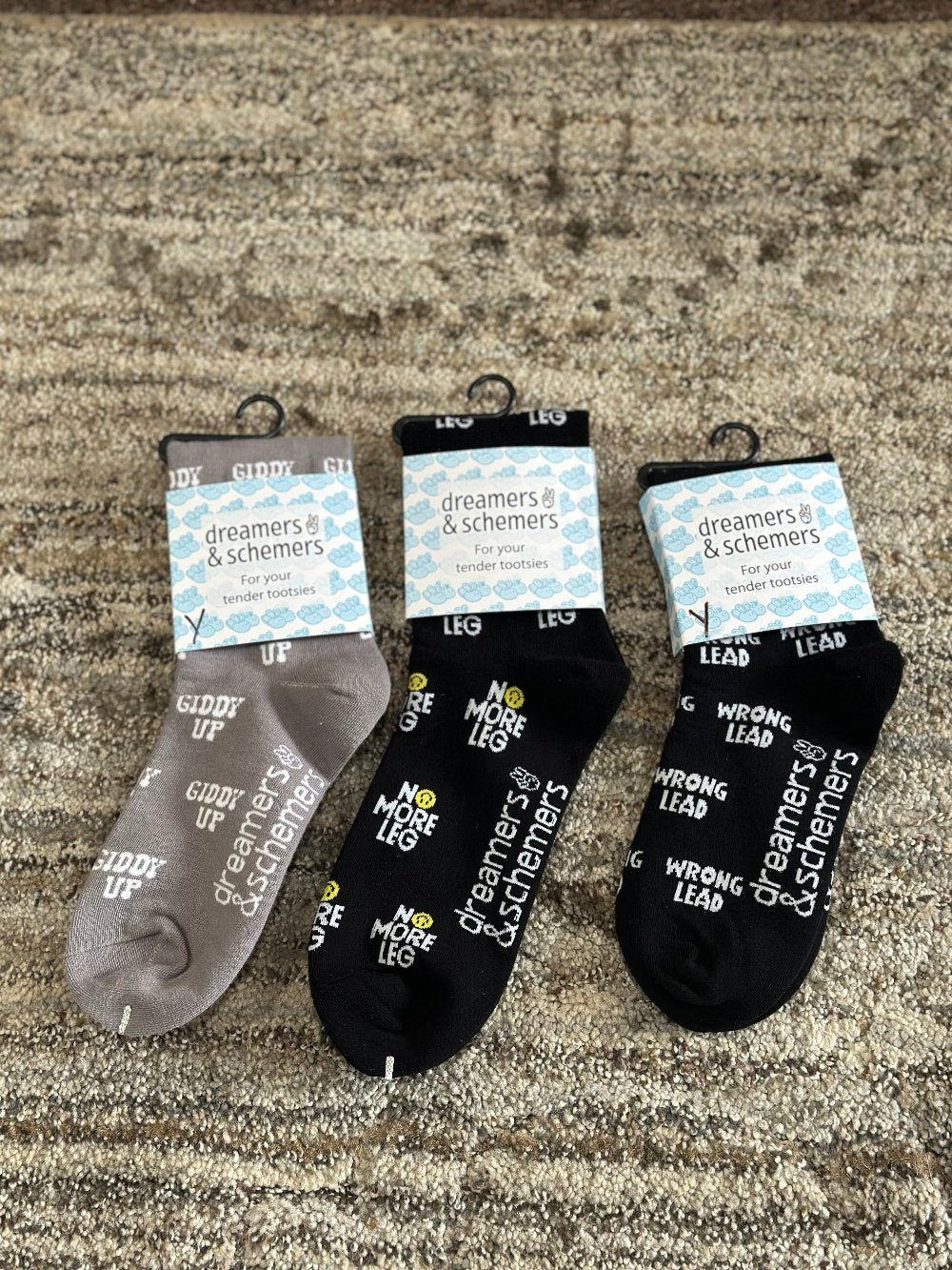 showing three crew socks each with different words for their design - giddy up - no more leg - and - wrong lead