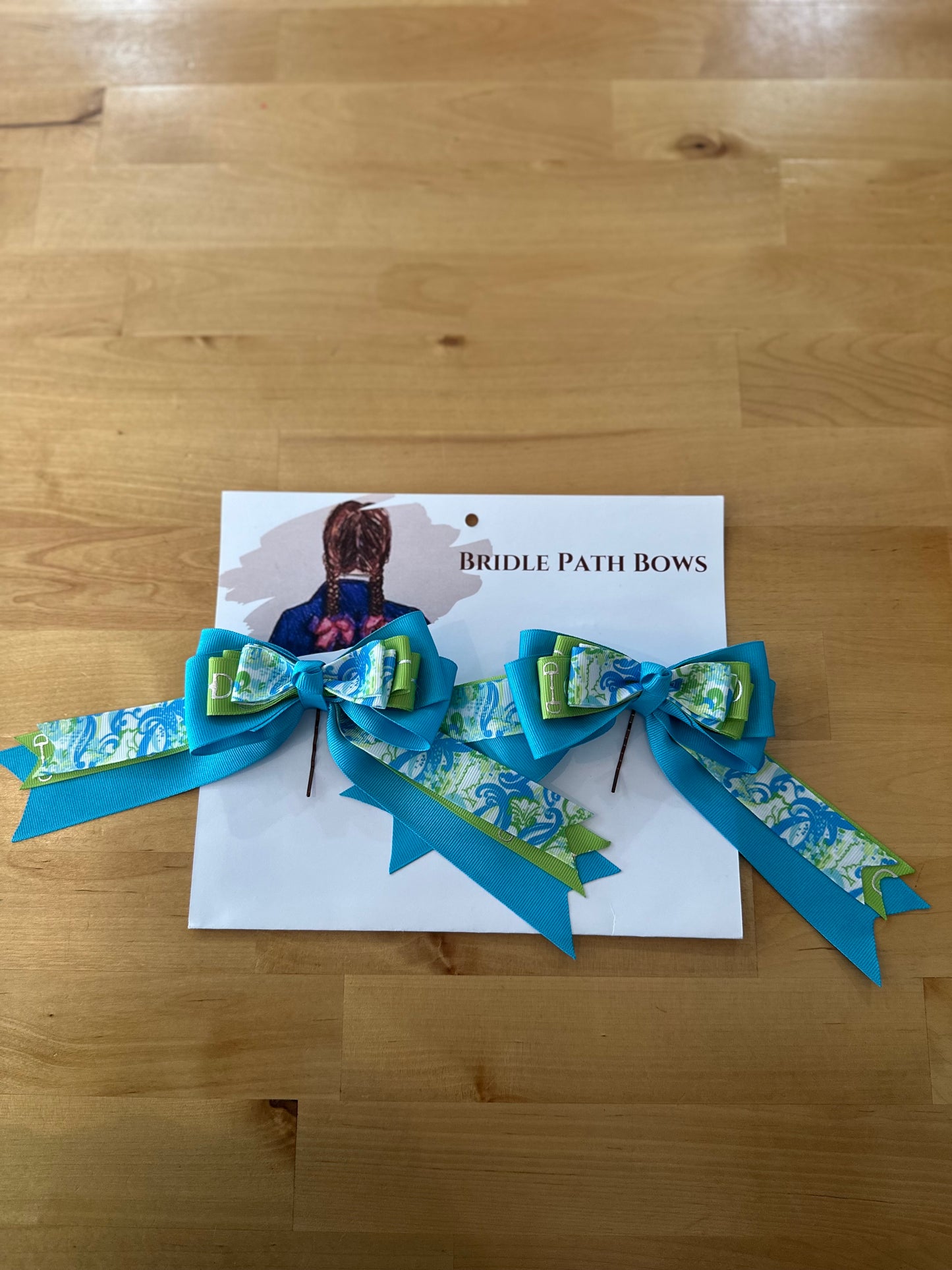 Image of children’s horse riding show bows, teal and green