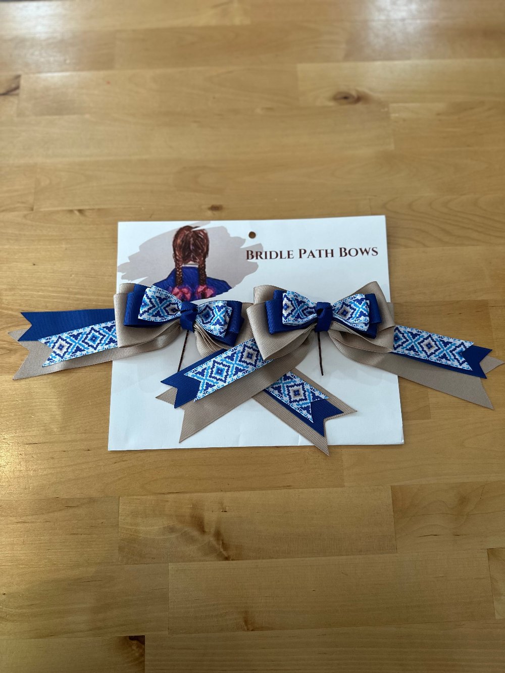 Image of children’s horse riding show bows, blue and grey
