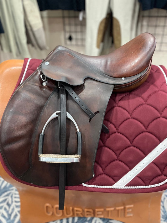 Brown leather english saddle on a burgundy saddle pad