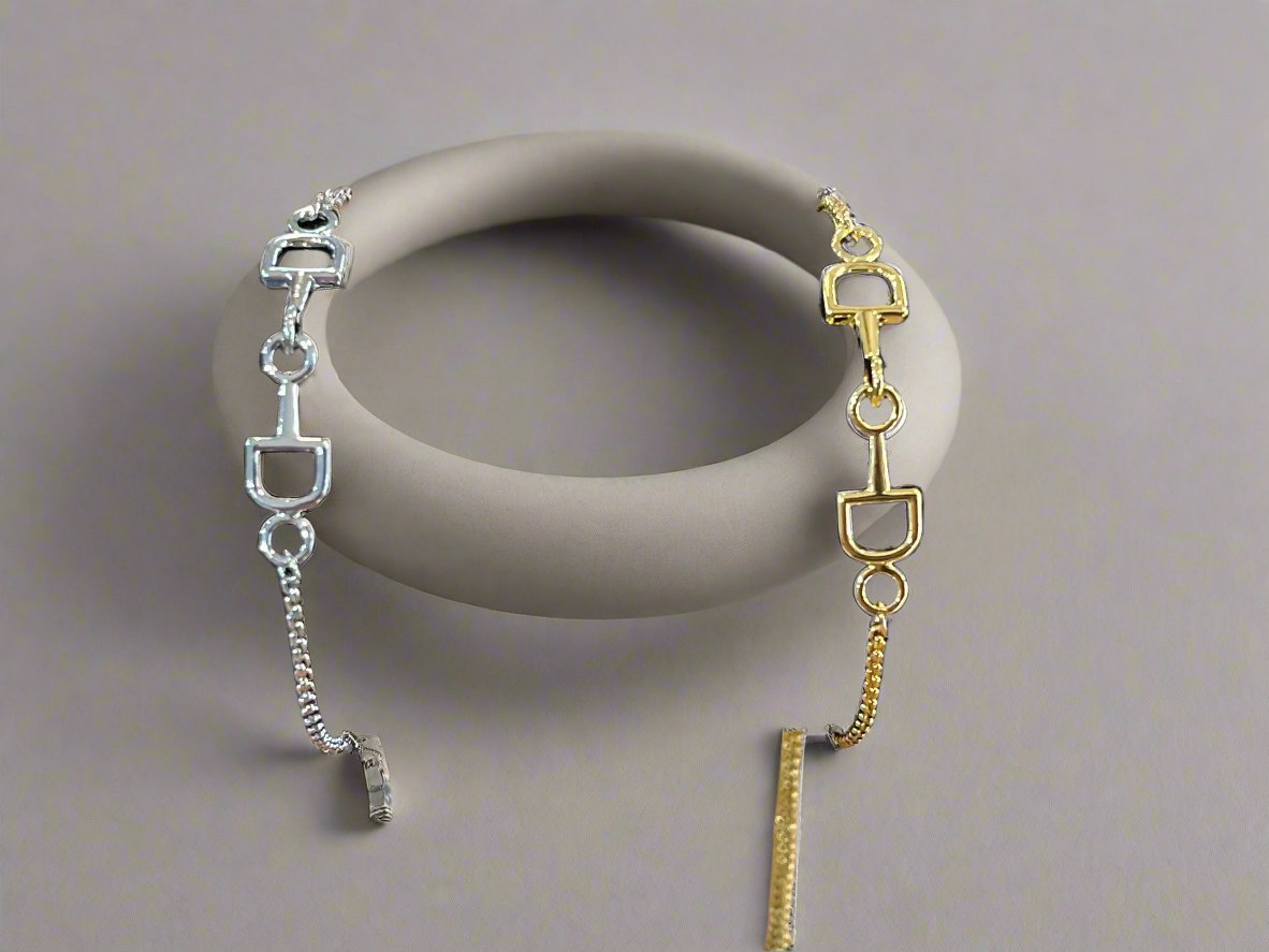 two dainty bracelets that look like a horse bit. one gold tone, one silver tone.