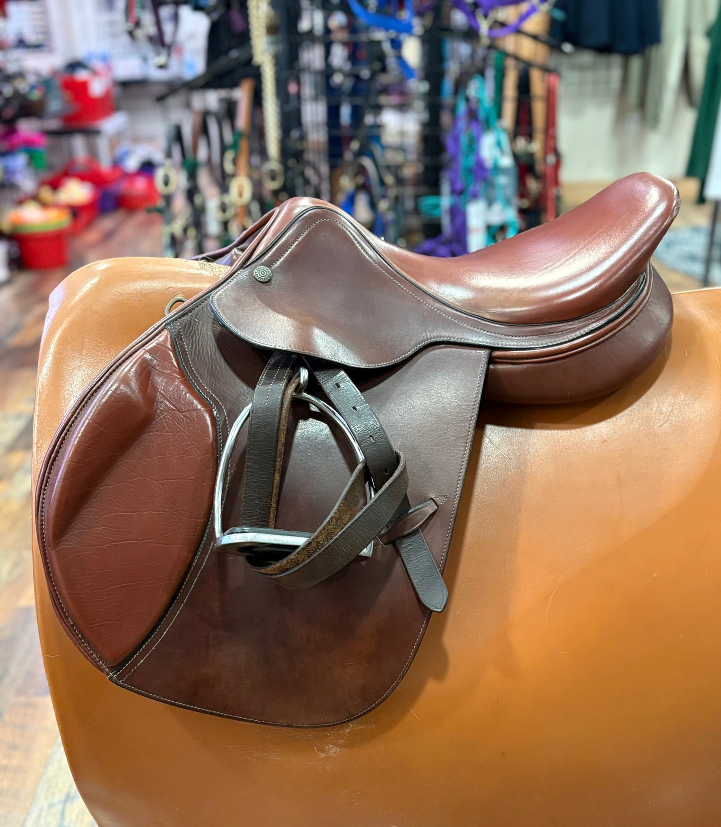 Two toned leather english saddle on a stand.