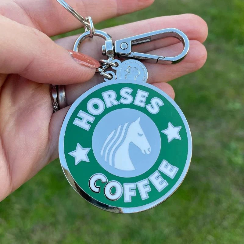 Hand holding a key chain that mimics the Starbucks logo but says Horses Coffee