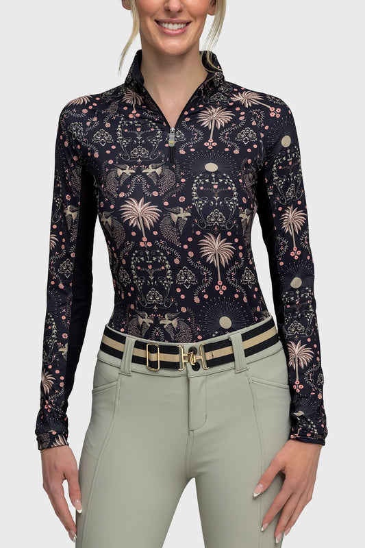 Woman model wearing a 1/4 zip print shirt with colors of black, muted coral and olive