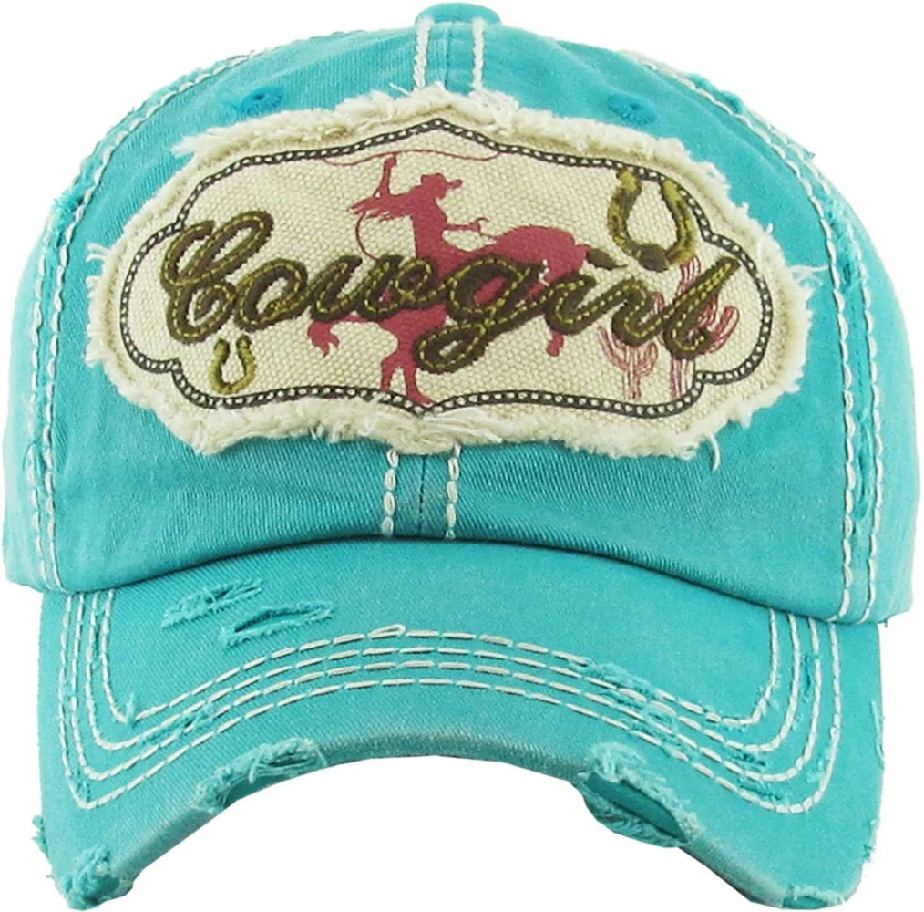 distressed grey ball cap with white stitching. front has a silhouette of a rodeo rider and "Cowgirl"