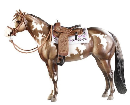 Model horse with a saddle and bridle on a white background