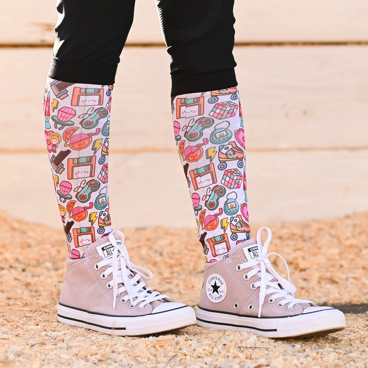 Knee-high patterned socks with high-top sneakers.