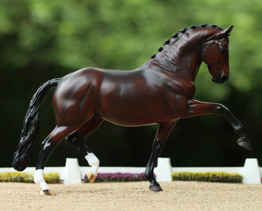 Model horse on a sandy surface with a blurred green background