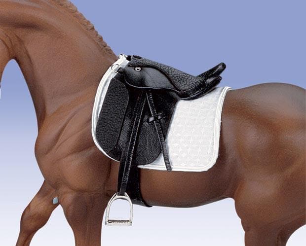 Horse with a black saddle and white saddle pad on a clear background