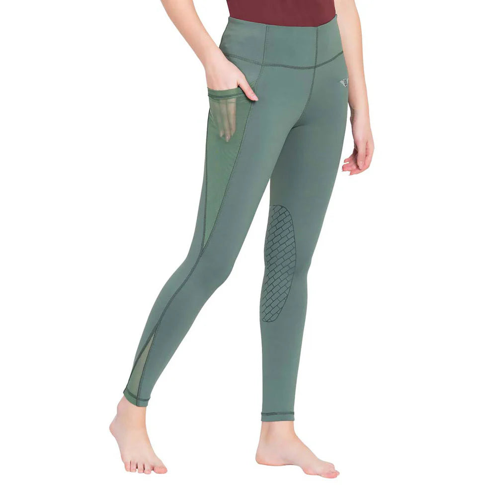 Model wearing green colored riding tights with a mesh side cell phone pocket