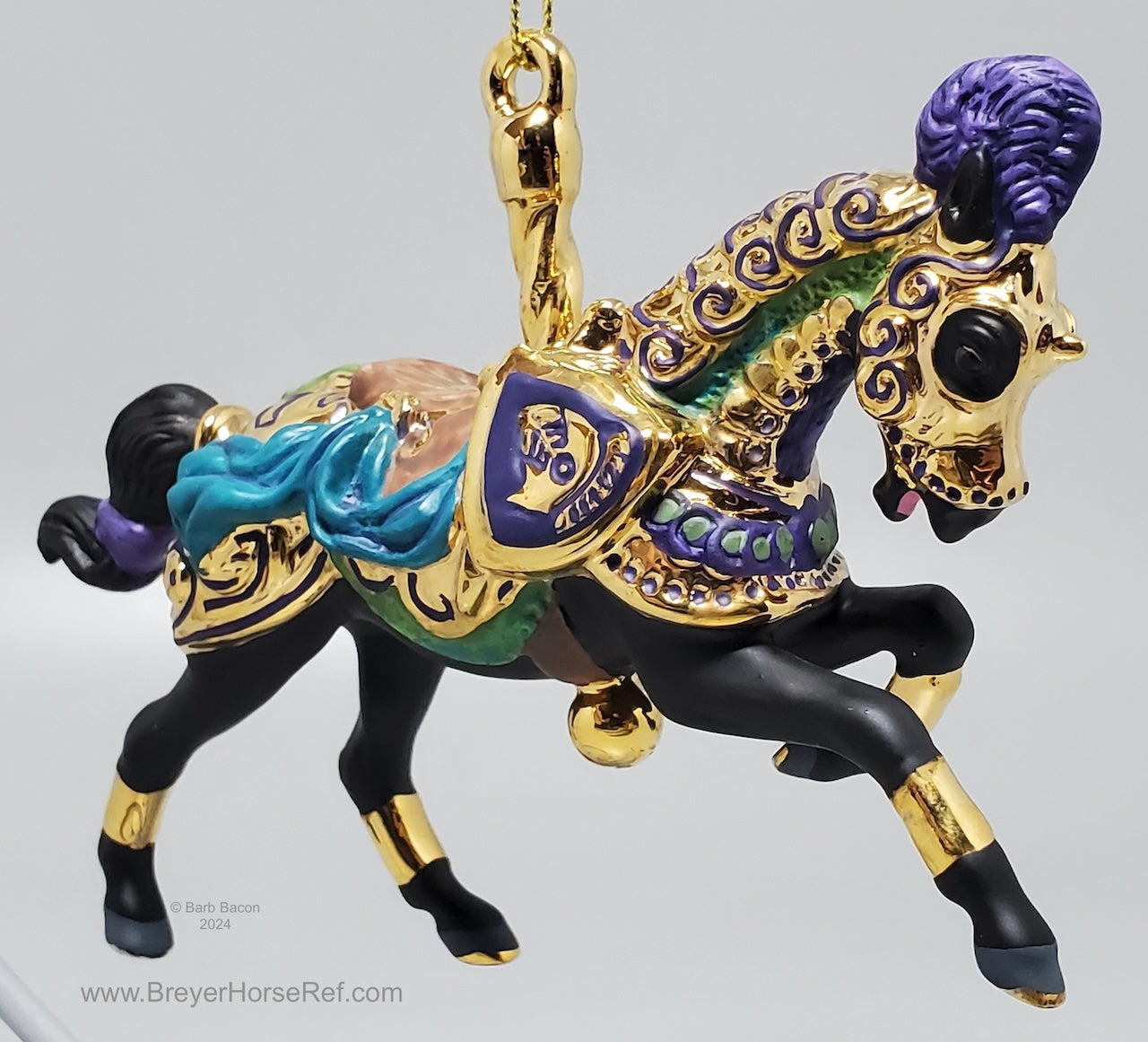 Decorative horse figurine with gold, purple, black and blue accents on a gray background