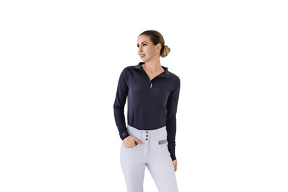 Woman wearing a black long-sleeve top and white riding pants on a white background