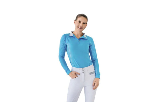 Woman wearing a blue long-sleeve top and white pants on a white background