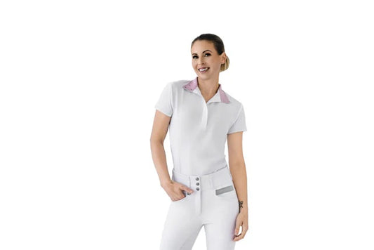 Woman wearing a white equestrian short sleeve shirt with pink accents on a white background