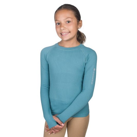 young equestrian wearing a lagoon colored seamless long sleeve shirt with thumb holes.