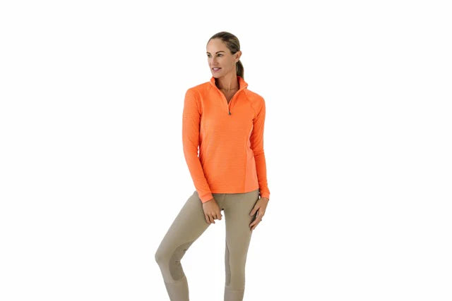 Woman wearing an orange long sleeve riding shirt on a white background