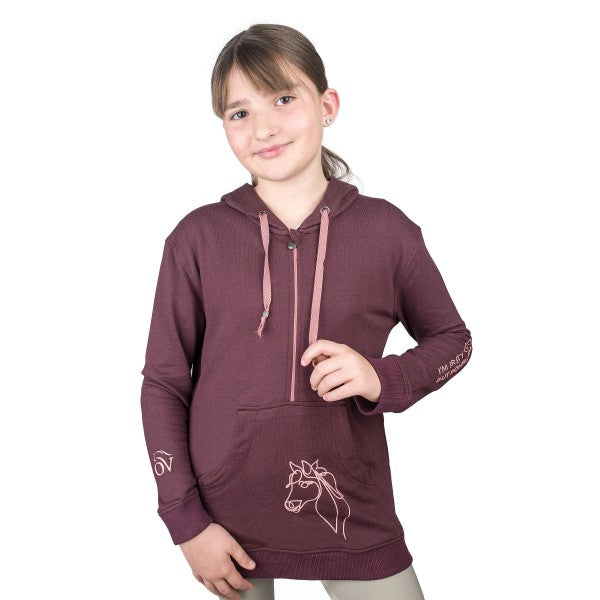 young girl wearing a plum colored hoodie with pink graphic of a pony on the pocket pouch and writing up the arm