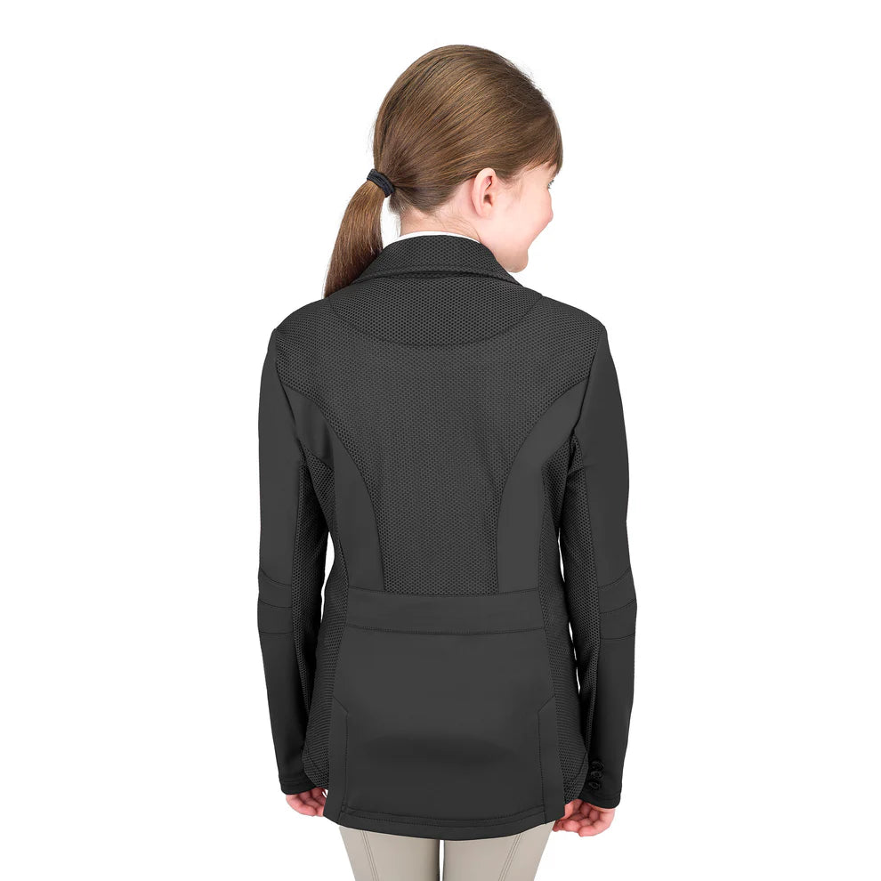 Rear view of a young girl wearing a riding show jacket with a white shirt and tan breeches on a white background.