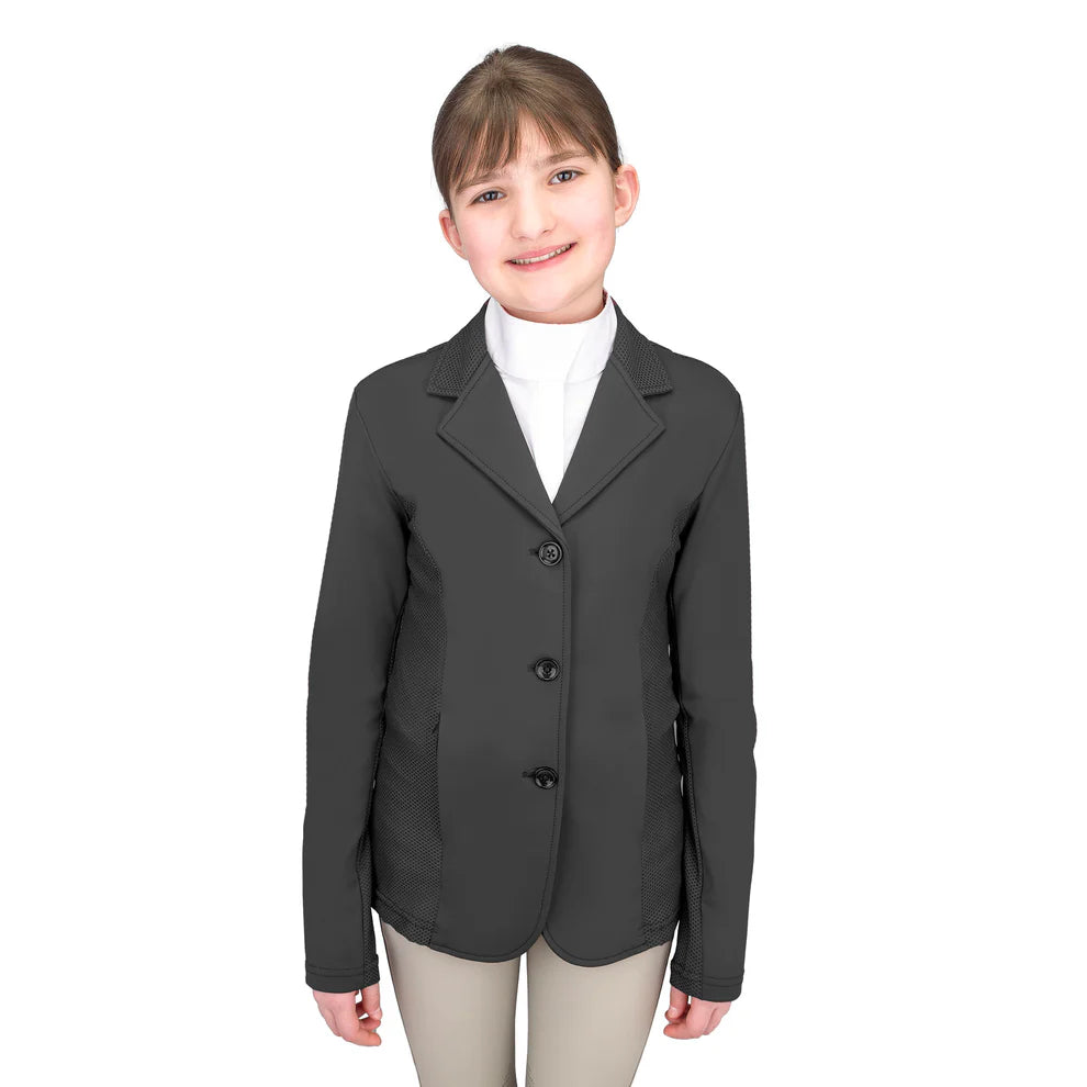Young girl wearing a riding show jacket with a white shirt and tan breeches on a white background.