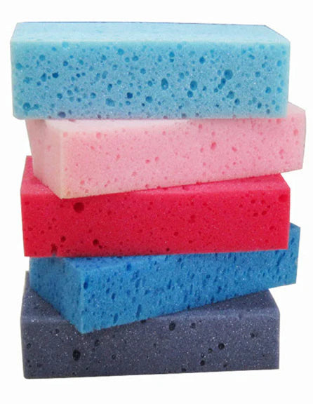 Stack of colorful sponges in blue, pink, and purple on a white background