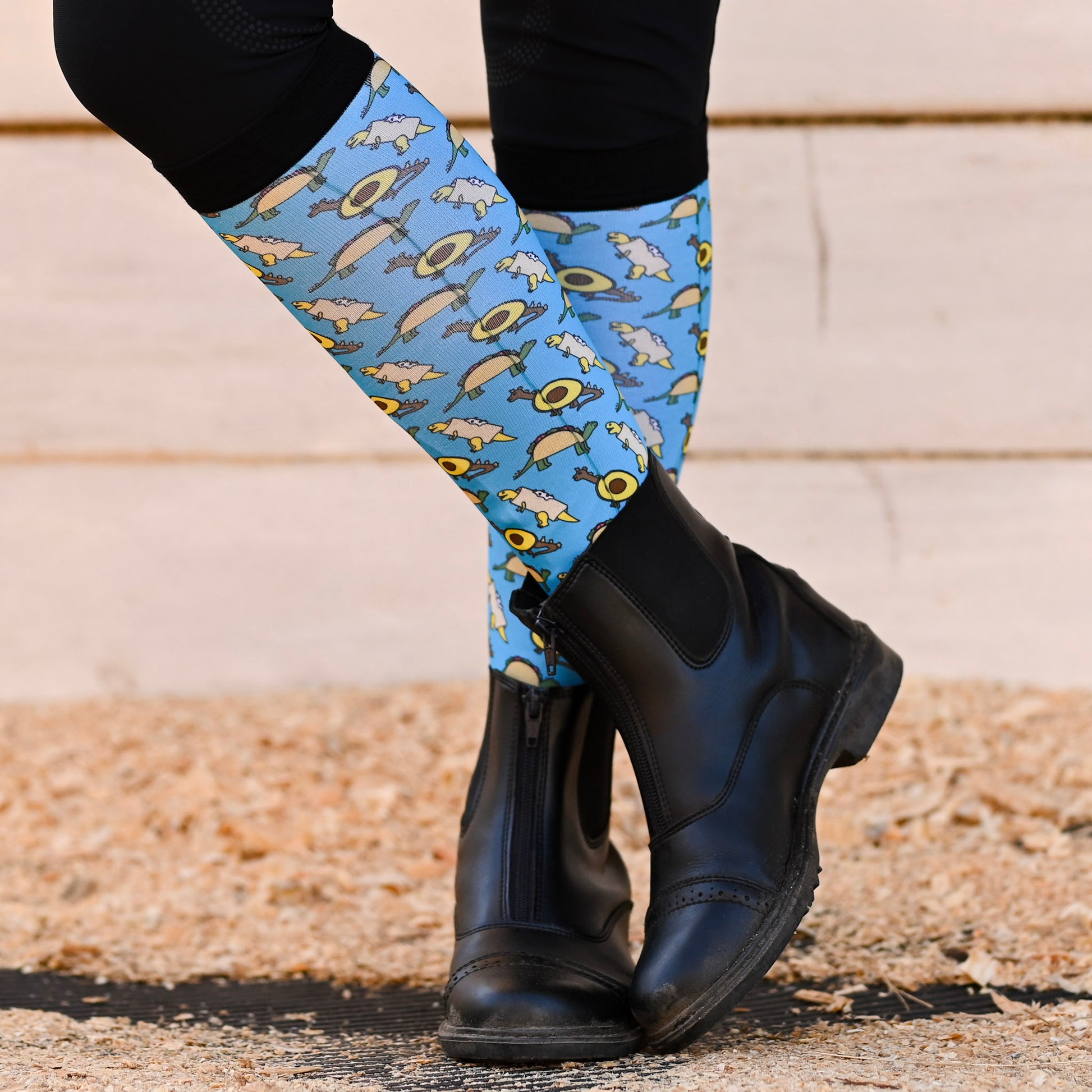 Blue patterned knee socks worn by a person with paddock boots on a neutral background