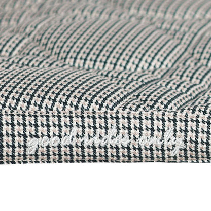 Close-up of a textured fabric with a houndstooth pattern.