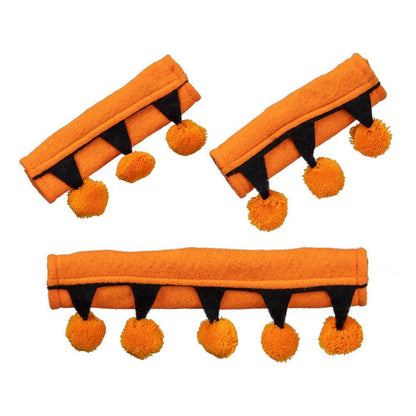 Three orange halter attachments with black accents and pom-poms on a white background