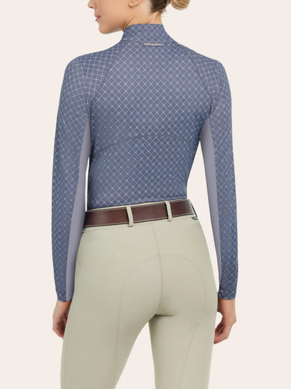 back side of an equestrian model wearing a long sleeve print riding shirt with tan riding pants