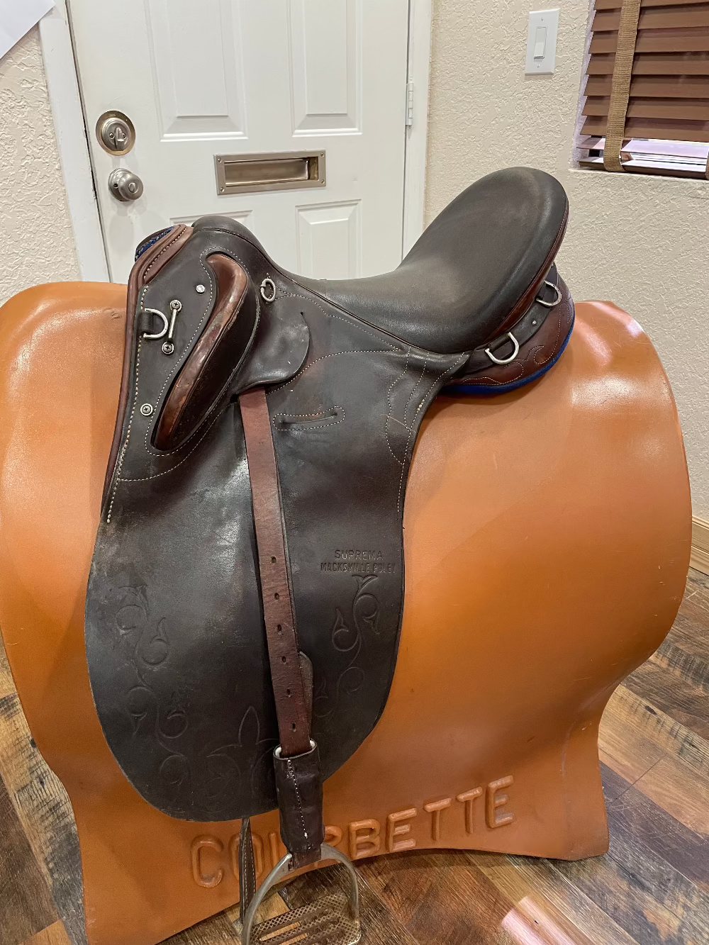 Brown Australian stock saddle with a high cantle, long flaps, and front thigh blocks