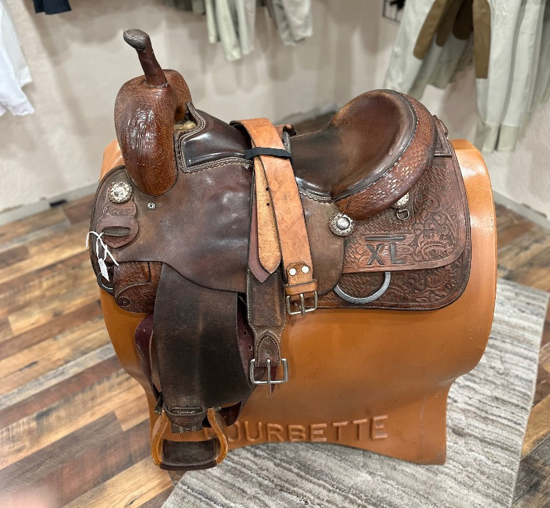 Brown leather western saddle with high horn and tooled leather
