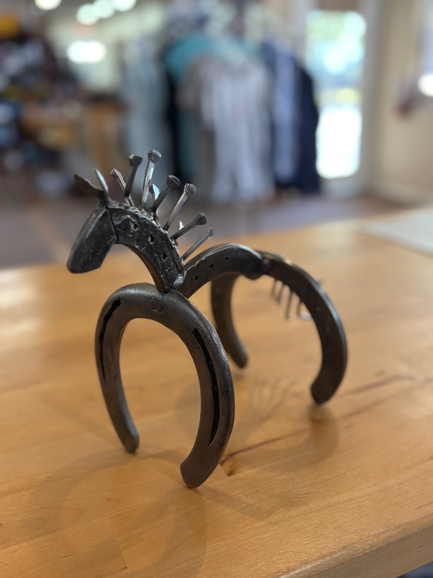 Decorative horseshoe with a horse head design on a wooden surface