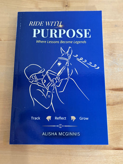 Blue book titled 'Ride with Purpose' on a wooden surface