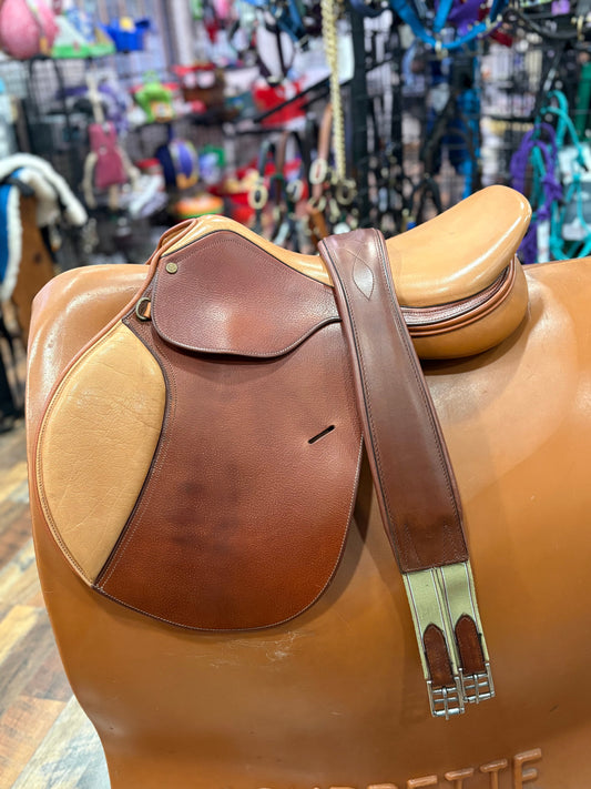 Two toned light brown leather close contact english saddle with leather girth shown on a stand.