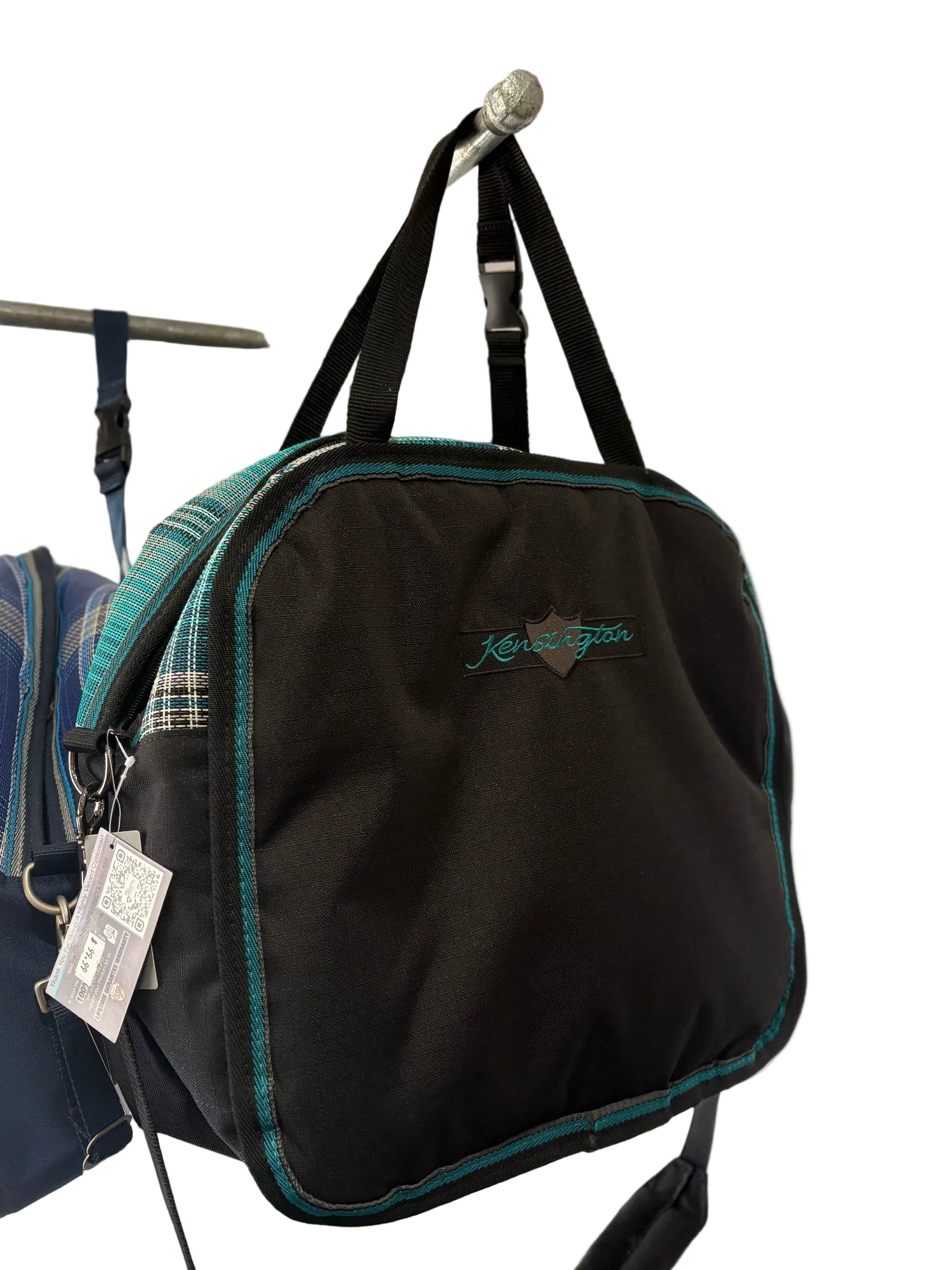 Black Kensington branded luggage with teal plaid accents.