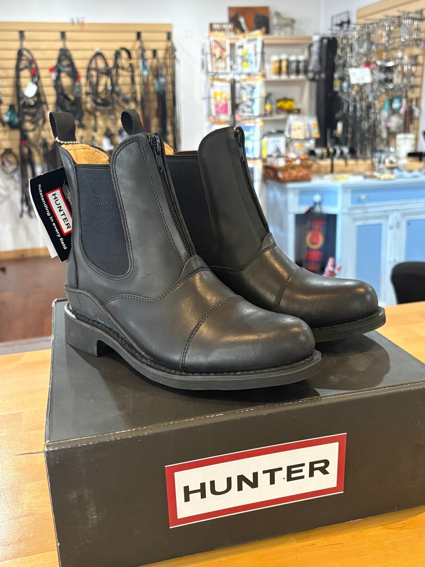 Pair of black Hunter boots on a branded box in a store setting