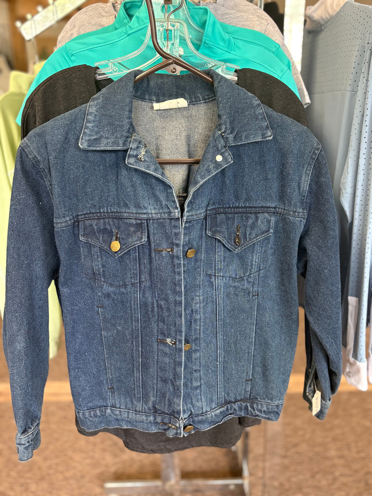 Blue denim jacket on a hanger with a blurred background