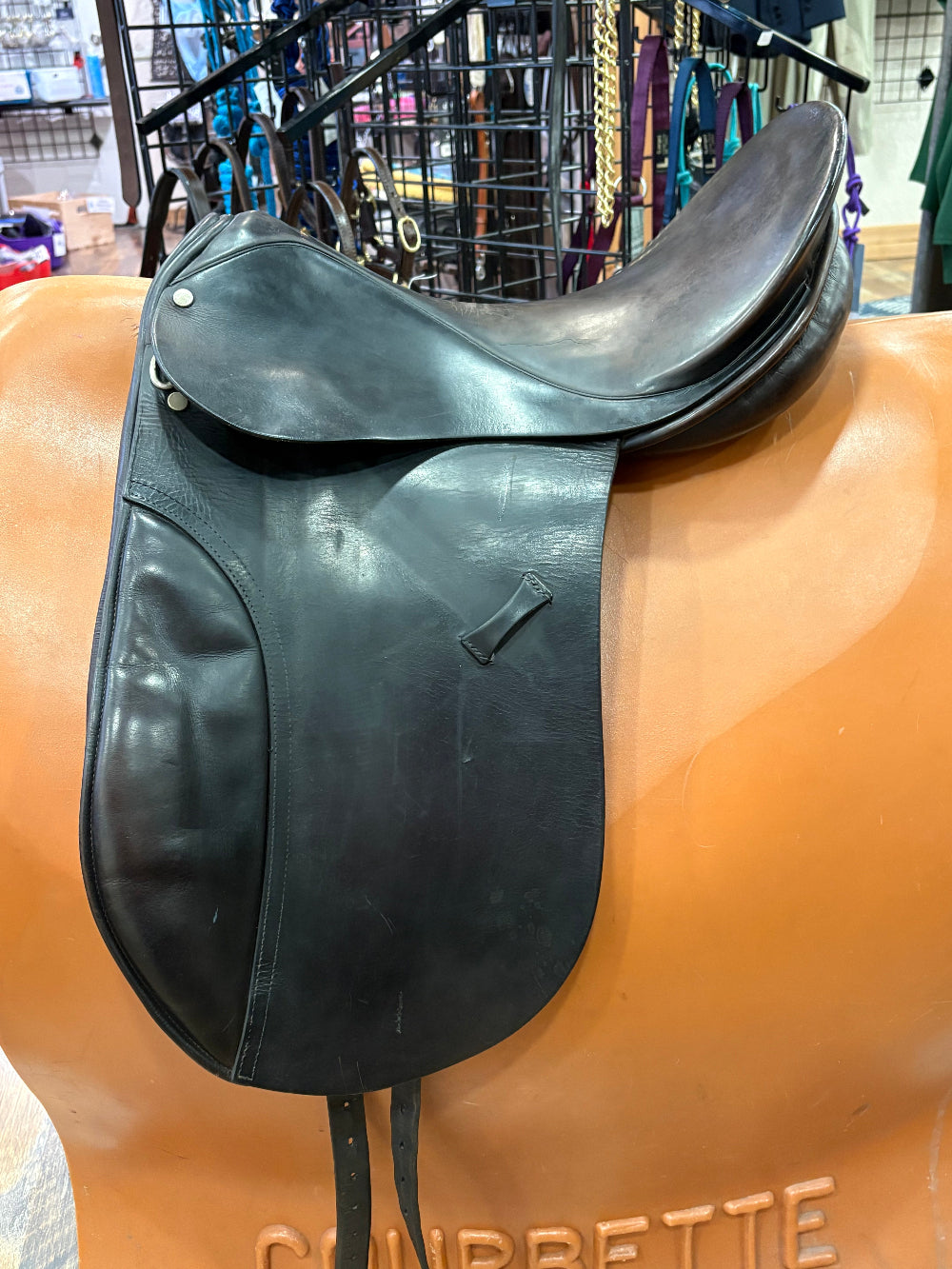 Black leather saddle on a brown horse statue with a blurred background