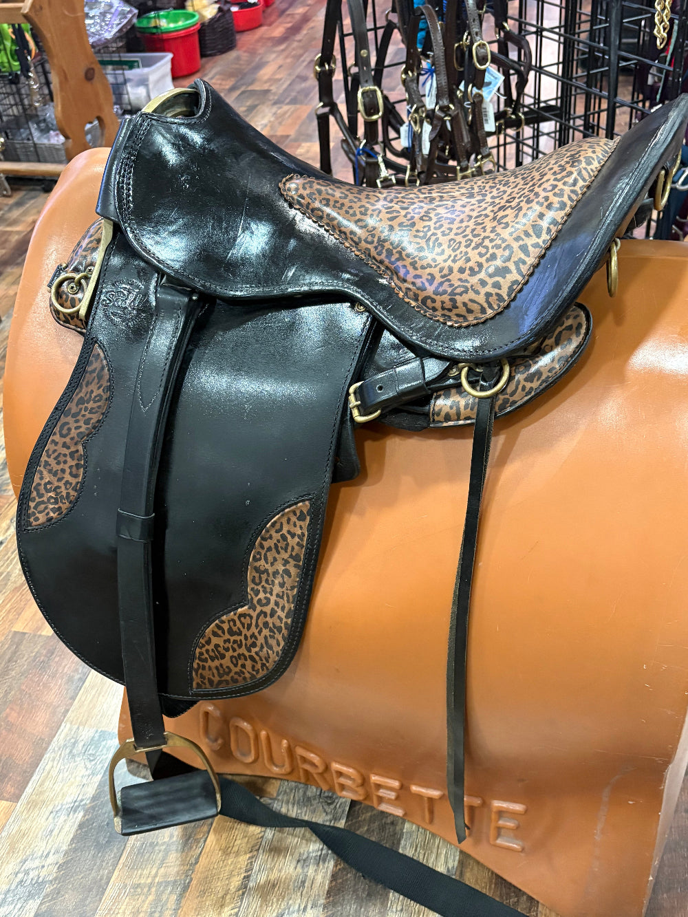 Black leather endurance saddle with leopard print seat and accents.