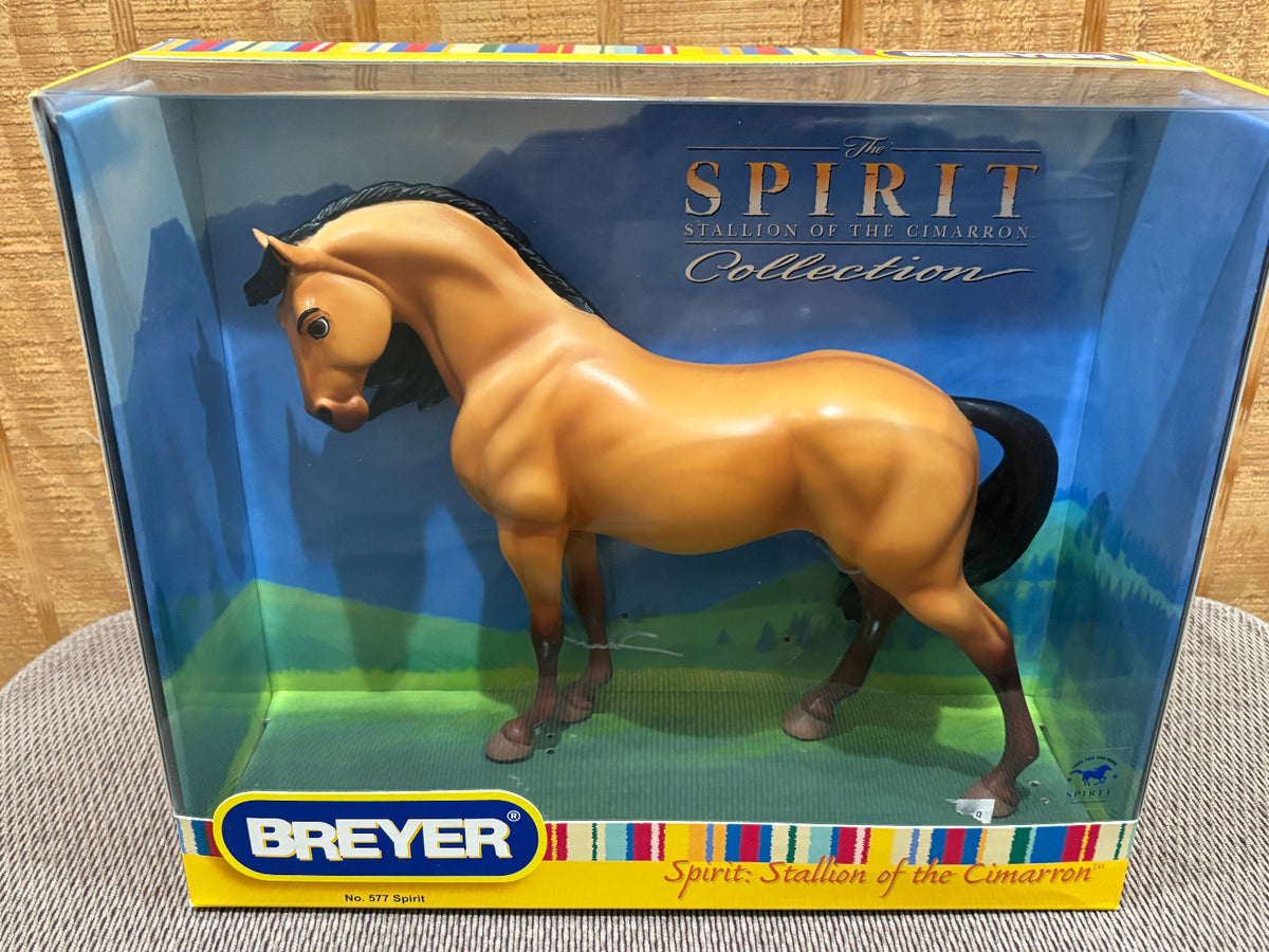 Breyer Spirit Stallion of the Cimarron toy horse in its original window box packaging, displayed on a textured gray surface against a wooden background.