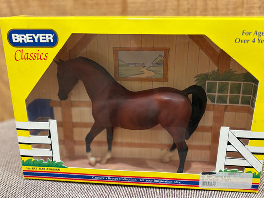 Breyer Classics model horse Bay Arabian in its original yellow window box packaging, showing a glossy brown horse inside an illustrated stable.