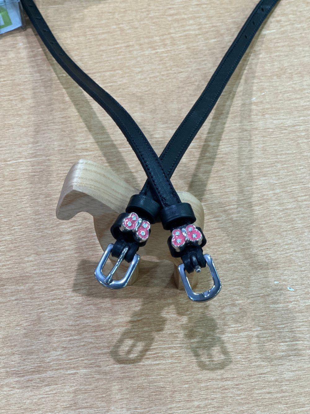 black leather equestrian spur straps with silver buckles. Pink butterflies with silver jewels