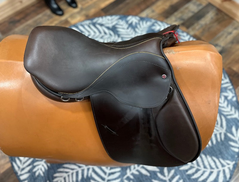 Beautiful brown leather english saddle with fine contrast stitching on the top outline of the seat.