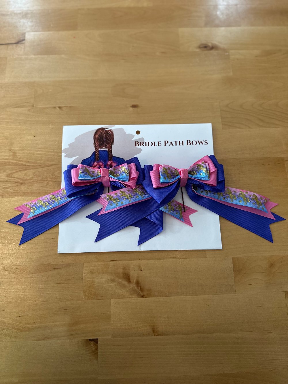 Image of children’s horse riding show bows, blue pink and gold glitter horse pattern