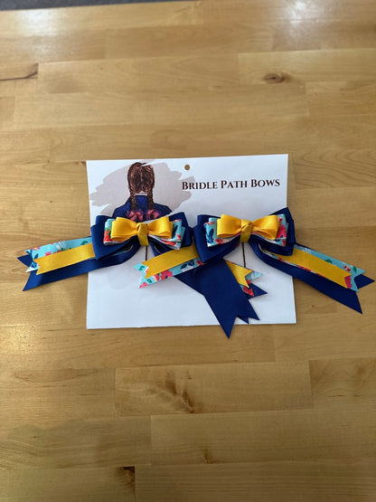 Image of children’s horse riding show bows, yellow light blue and dark blue with flower pattern