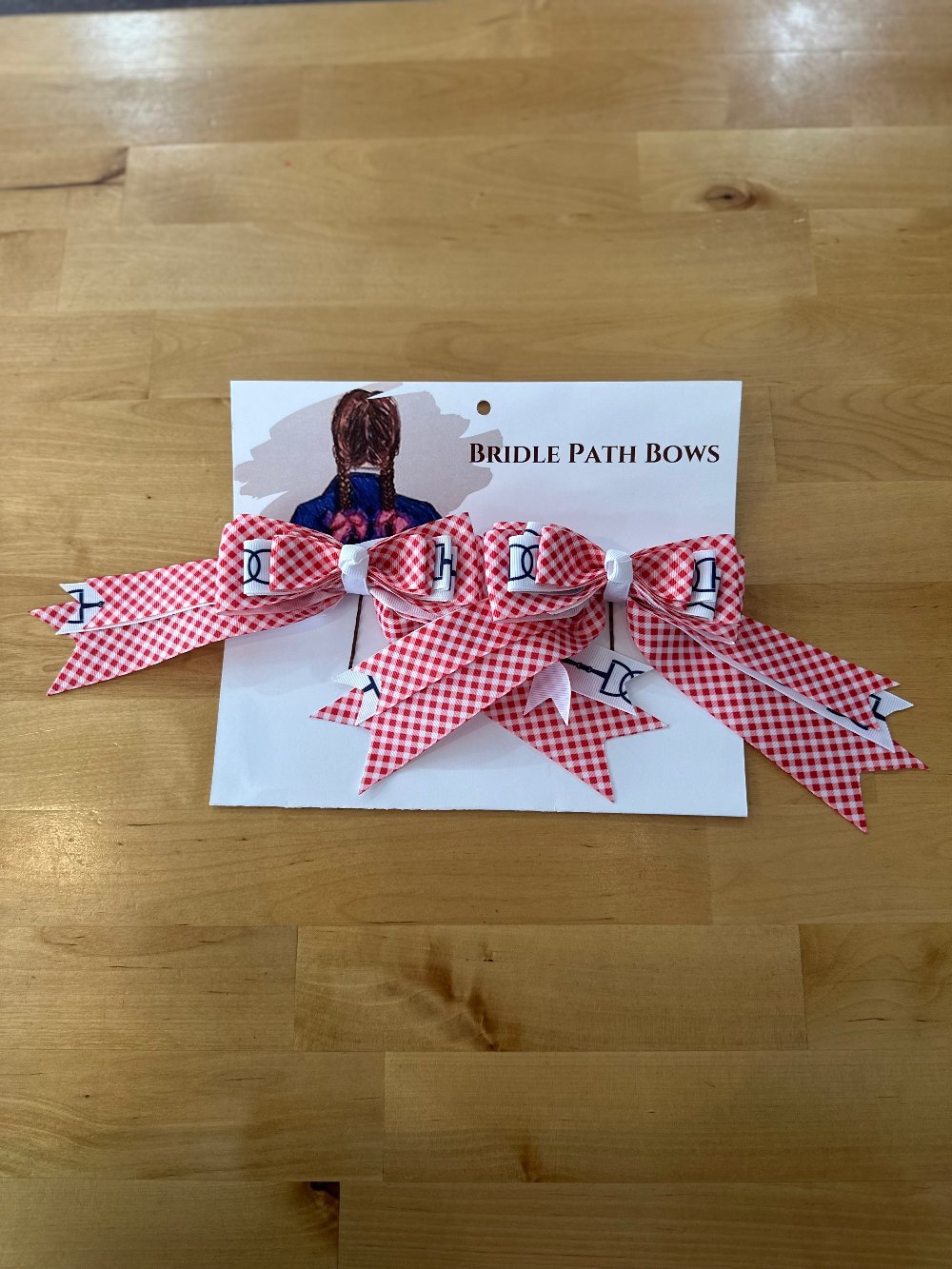 Image of children’s horse riding show bows, red and white gingham pattern